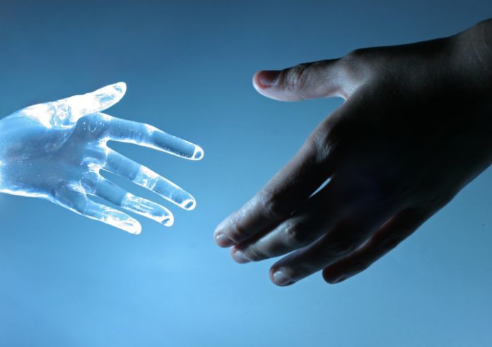 A human hand touches an artificial hand.